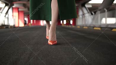 Woman`s legs in high heel shoes walking on road