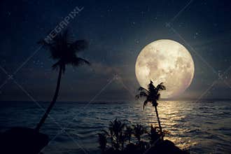 Beautiful tropical beach with milky way star and full moon in night skies.