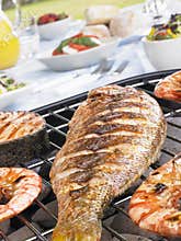Fish And Prawns Cooking On A Grill