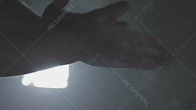 Unrecognizable male gymnast chalking his hands in preparation for training