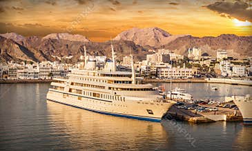 Port of Muscat in Oman with ships at sunset