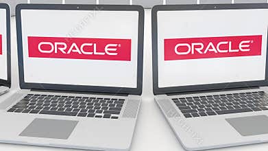 Laptops with Oracle Corporation logo on the screen. Computer technology conceptual editorial 4K clip, seamless loop