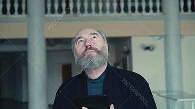 Irritated old man chatting on the tablet in 4K