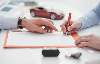Driver signing a car insurance