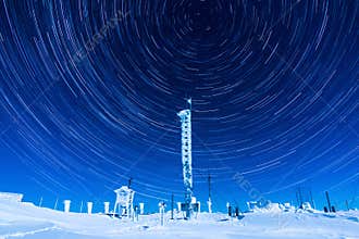 Beautiful star trails on the night sky during a clear winter night while spending time on top of a mountain