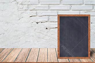 Chalkboard wood frame, blackboard sign menu on wooden table and with brick background.