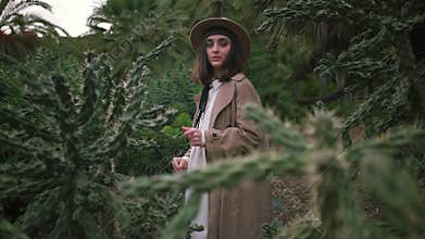 A beautiful girl is exploring the cacti park
