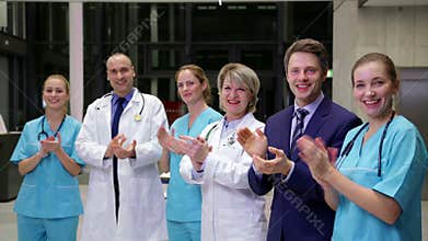 Team of doctors and businessman applauding during meeting