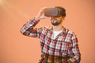 Composite image of casual man man holding virtual glasses on a pink background