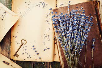 Retro still life with vintage books, key and lavender flowers, nostalgic composition on wooden table top view.