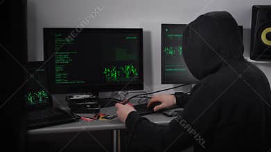 A man in a black jacket and a hood on his head trying to break into someone else`s bank card. In this he was helped by