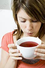 Woman blowing on cup of soup