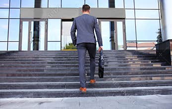Business executive with briefcase going up the stairs.