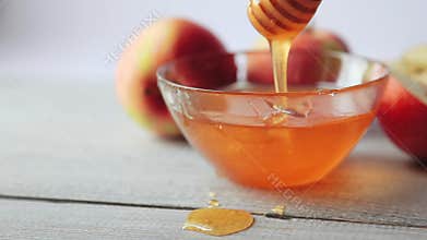 Movie of honey dripping. Apples on wooden table. Traditional celebration food for the Jewish New Year. Concept Rosh Hashana.