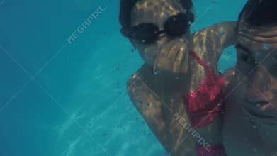Dad and daughter in the pool underwater. man and girl teenager bathe in pool underwater