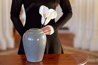 Woman with cremation urn at funeral in church