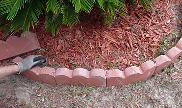 Man Placing Red Concrete Landscape Edging