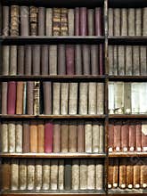 old books stacked on wooden shelves