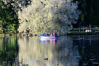 Evening Gatchina Park is lit by the summer sun.Family swims on a boat on the lake.
