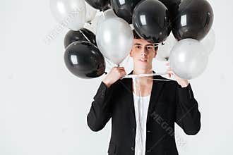 Smiling man holding air balloons