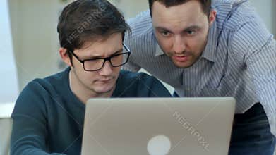Teacher helping student with his project in classroom