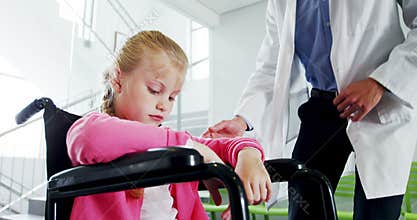 Disable girl sitting on wheel chair talking to doctor