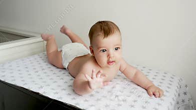 Baby boy in diaper lying on her belly on the diaper with the stars