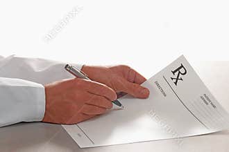 Doctor writing out prescription on RX form