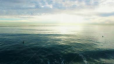 Aerial shooting of surfers in the Pacific coast at sunrise