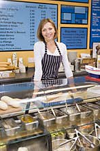 Woman standing at counter in restaurant smiling