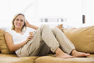 Woman in living room listening to MP3 player