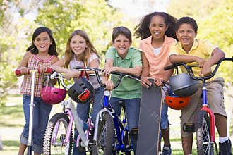 Friends with bicycles scooters and skateboard