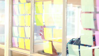 Casual businesswoman looking at post it