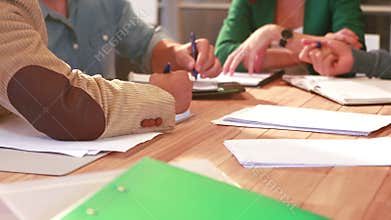 Casual business team taking note during meeting