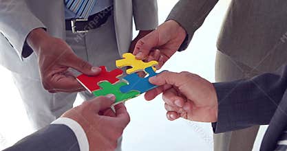 Business colleagues holding pieces of puzzle