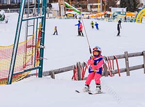 An undefined little skier in the ski lift