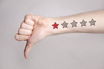 Man hand showing thumbs down and one star rating