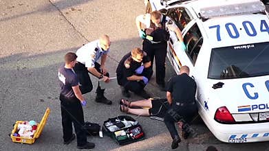 Medical people and police helping heart attack man