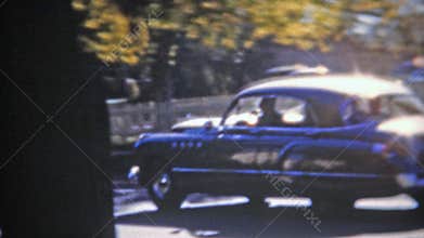 SPRINGFIELD, MISSOURI 1953: Family driving off in new car into the suburban-scape.