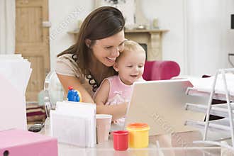 Mother and baby in home office with laptop
