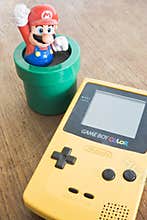 Game Boy Color device with Super Mario Bros figure