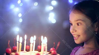 Birthday of the little girl she blows out candles on cake. Slow motion