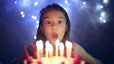 Birthday of the little girl she blows out candles on cake. Slow motion
