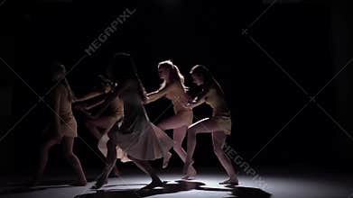 Graceful contemporary dance of five dancers in white clothes on black, shadow, slow motion