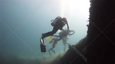 Divers over the edge of the reef and in the sun