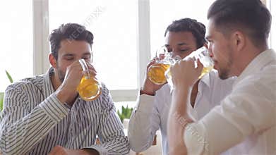Three cheerful men in casual wear toasting