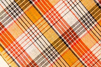 The texture of white checkered, orange, red, black cotton fabric