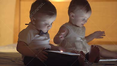 Two children playing with a tablet