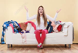 Helpless woman sitting on sofa in messy room home.