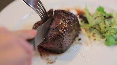 Cutting the meat on a plate close-up